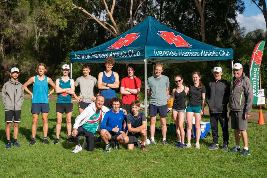 A group photo of runners in front of the Club tent